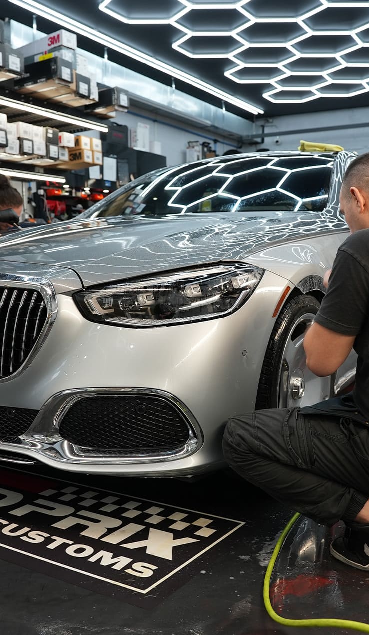 Close-up of STEK clear bra edge wrapping during PPF installation at Grand Prix Customs NYC