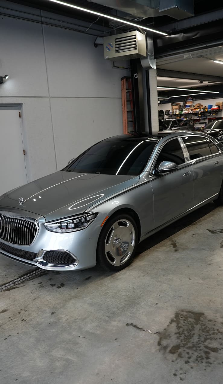 Technician cleaning Mercedes surface before STEK Paint Protection Film installation at Grand Prix Customs in Brooklyn, NY